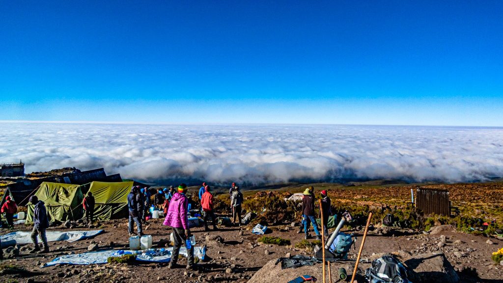 Porters carrying water jerrycans into a high camp on Mount Kilimanjaro