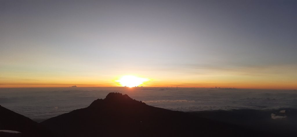 Sunrise over a sea of cloud behind the jagged peak of Mawenzi on Mount Kilimanjaro